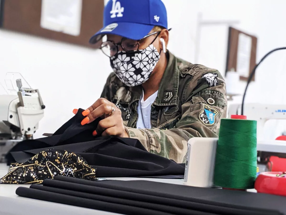 Person working at a sewing machine, representing the Columbus Fashion Alliance. A Gravity Partner, and creative collective supporting the growth of the fashion industry in Columbus, Ohio.