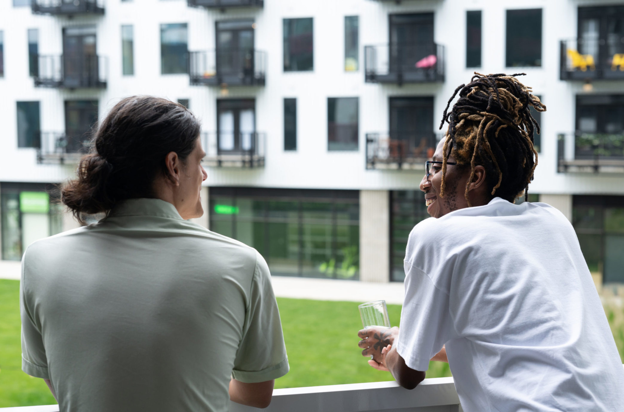 Two people leaning on the railing, engaged in conversation at a Gravity community space. A place for discovery, questioning, creation, and transformation.