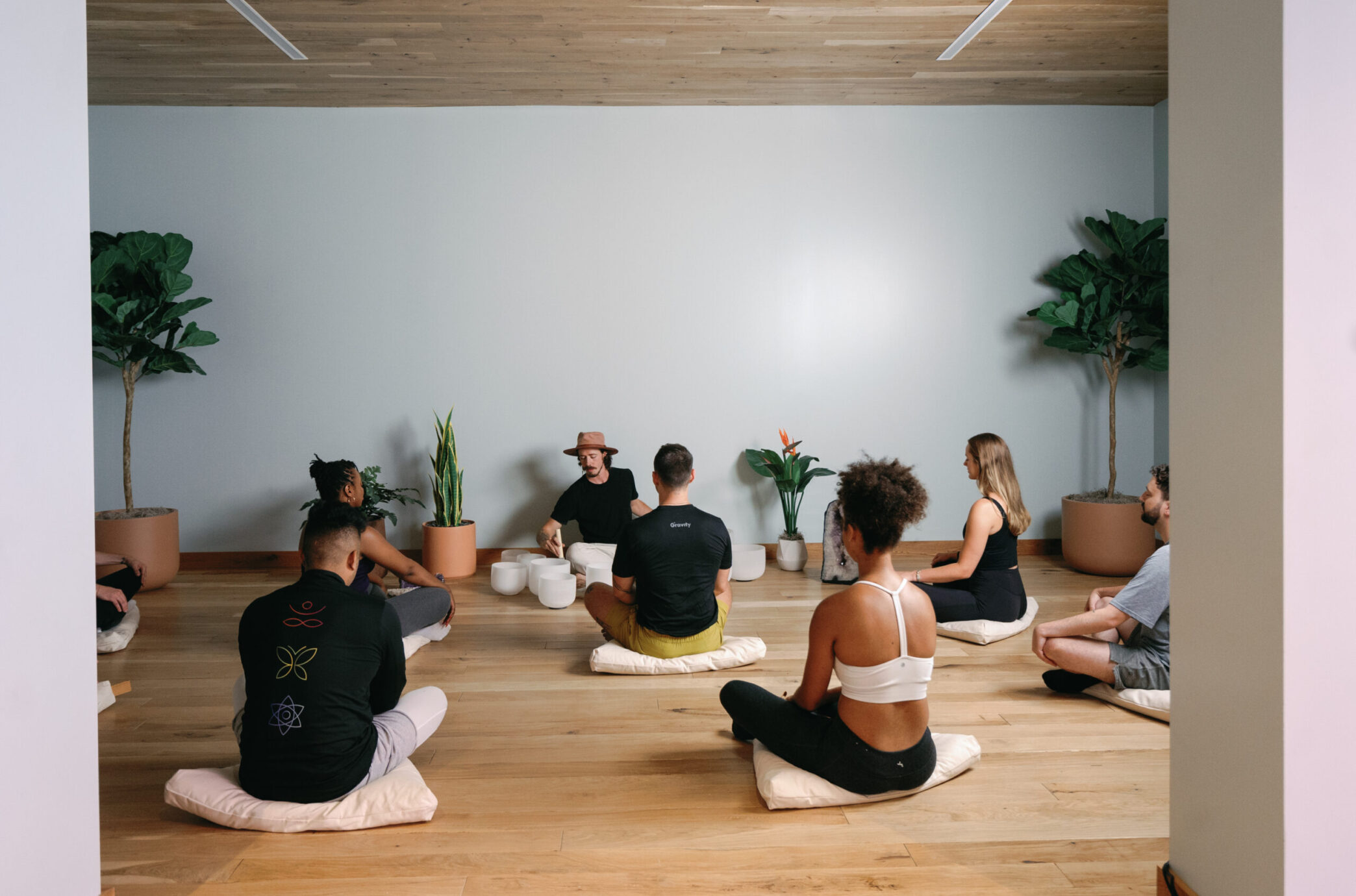 Young adults participate in a vibrant yoga class at Gravity Building B, a wellness-focused space offering diverse classes and community engagement.
